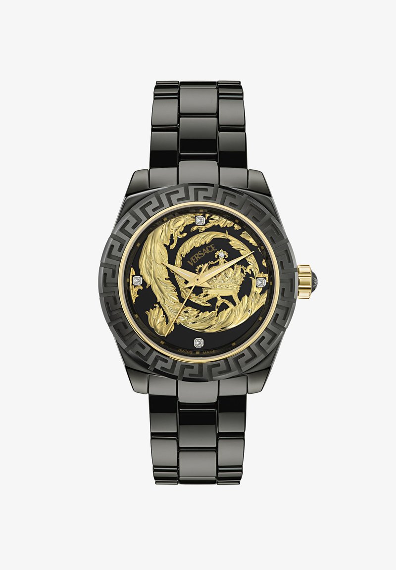 Orologio in metallo nero con un quadrante dorato ornato di un motivo a foglia, accenti di diamante e un motivo a chiave greca sulla lunetta. Prodotto in Svizzera.