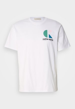 White cotton t-shirt featuring a multicolored graphic design with circular shapes and "Calvin Klein" logo on the front. Short sleeves, crew neck.