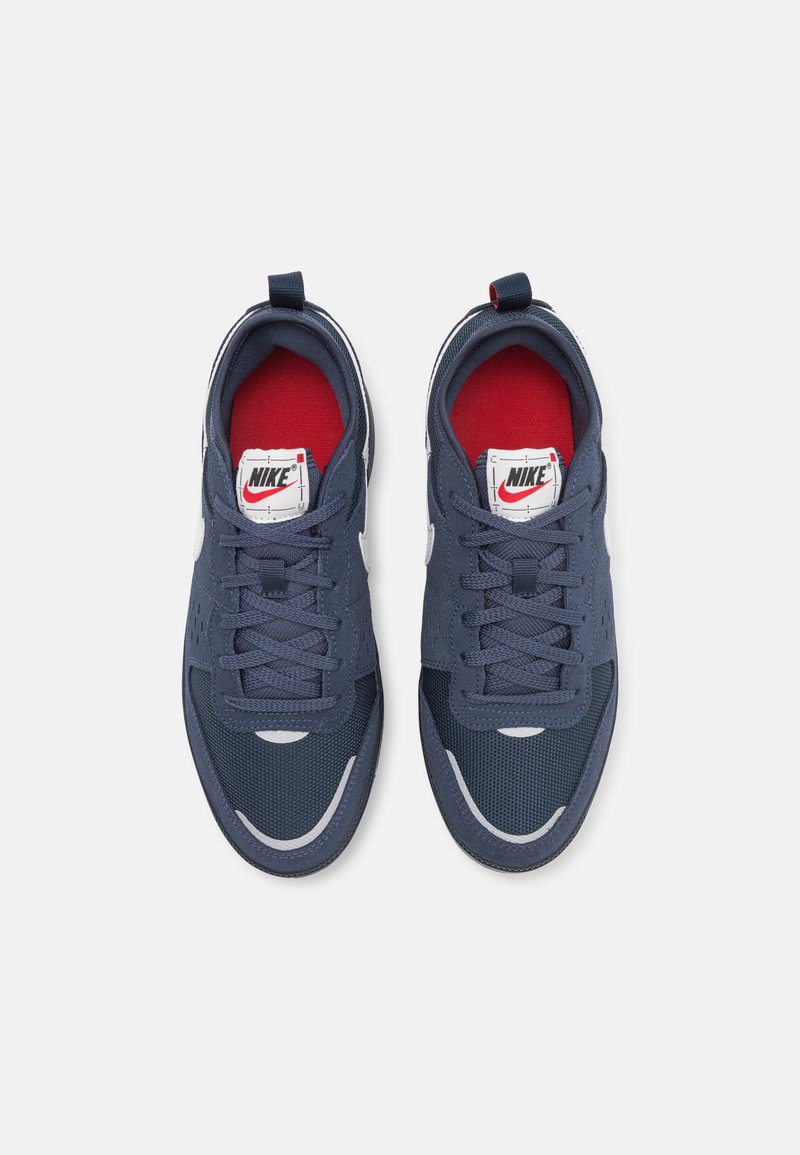 Baskets Nike avec une empeigne en maille marine, doublure intérieure rouge, accents blancs et une finition texturée. Comprend des lacets et une languette rembourrée.