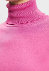 Strakke turtleneck trui in felroze, gemaakt van soepel, rekbaar stof met geribbelde nekdetails en een naadloze afwerking.