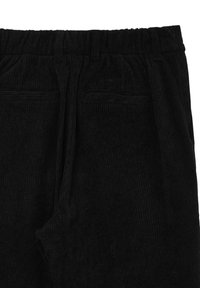 Pantaloni in corduroy neri con texture a righe, vita elasticizzata e due tasche frontali. Il tessuto sembra morbido e leggermente lucido.
