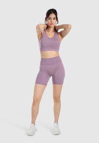 Conjunto de sujetador deportivo y pantalones cortos de tiro alto en tejido suave; diseño de espalda nadadora; ajustado con un aspecto minimalista.