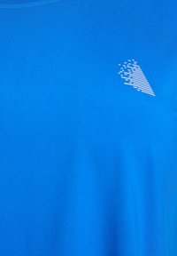 Helles blaues Gewebe mit einem kleinen weißen abstrakten dreieckigen Logo aus horizontalen Linien im oberen rechten Bereich.