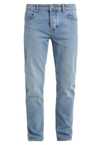 Světle modré džíny z denimu s předním knoflíkem, zipem a pěti kapsami, vystavené vertikálně na bílém pozadí.