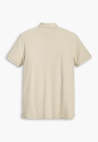 Polo beige à manches courtes vu de dos, avec un col classique et des détails de couture simples.