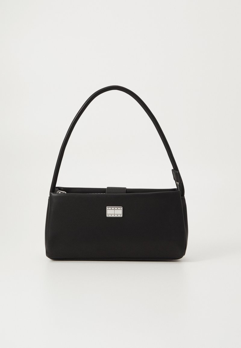 Sac à main rectangulaire noir avec une seule anse arquée et une petite plaque logo Tommy Jeans argentée sur le devant.