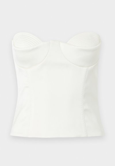 Λευκό κορσέ ύφους τοπ χωρίς τιράντες με διαμορφωμένα cups, λείο ύφασμα και δομημένες ραφές για εφαρμοστή γραμμή, εμφανίζεται σε απλό φόντο.