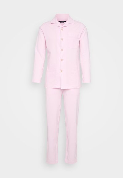 Világos rózsaszín pamut pizsama szett, hosszú ujjú, gombos inggel és azonos színű, egyenes lábú nadrággal, amelyen mellzseb található.