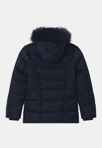 Giacca puffer navy con cappuccio staccabile foderato in pelliccia, caratterizzata da una texture trapuntata e cuciture orizzontali sul retro.