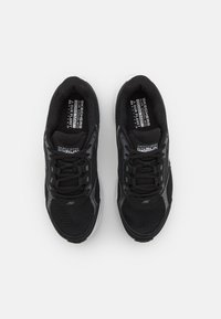 Černé sportovní boty s textilním svrškem, šněrováním a reflexními akcenty. Disponují odpružením a texturovanou podrážkou pro lepší přilnavost.