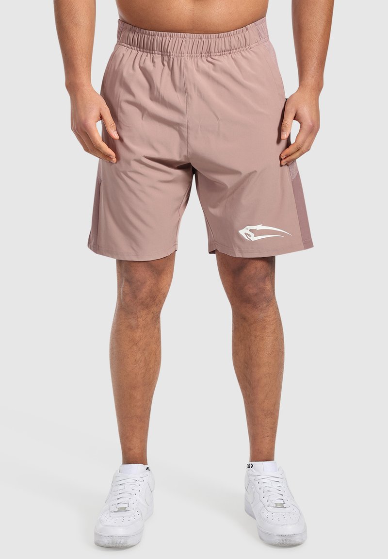 Ljust rosa träningsshorts i slät tyg med elastisk midja, med sidopaneler och en vit logotypdetalj.