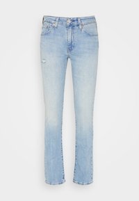 Jean en denim bleu clair à coupe droite, avec une zone légèrement usée et un ourlet effiloché. Style classique à cinq poches.