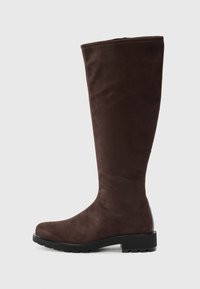 Botte en suède marron foncé, haute, avec un bout arrondi, une semelle épaisse noire et un petit talon carré, présentée de profil sur un fond blanc.