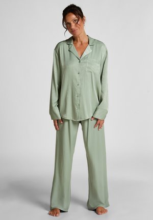 Grünes Satin-Pyjama-Set mit einem langärmligen, knopfbaren Oberteil, das über eine Brusttasche verfügt, sowie lässig geschnittenen Hosen. Sanfte Textur und entspannter Sitz.