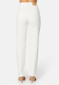 Witte denim broek met een rechte pasvorm, voorzien van achterzakken en een rechthoekig leren label op de tailleband.