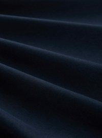 Tissu bleu marine foncé avec une texture lisse, présentant des plis doux et une finition mate, mettant en valeur sa capacité à draper et la profondeur de sa couleur.