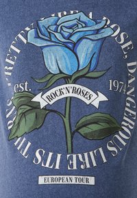 Grafika plave ruže na tamnoplavoj tkanini. Tekst uključuje "ROCK'N'ROSES" i "EUROPSKA TURNEJA" sa vintage dizajnom.