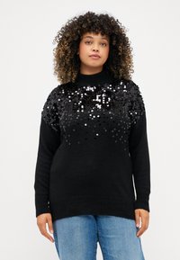 Juodas megztinis, pagamintas iš minkštos medžiagos, su blizgučiais dekoruota viršutine dalimi. Jis turi apvalų iškirpimą ir ribotos formos rankoves, yra laisvo silueto.