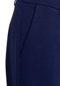 Marineblauwe broeken van een gestructureerde stof, met een vlakke voorkant, plooien en zijkanten met zakken, in een getailleerde snit voor een aansluitende look.