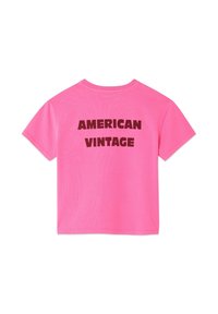Różowy bawełniany t-shirt z krótkimi rękawami i okrągłym dekoltem. Na plecach znajduje się wyraźny, ciemnobrązowy napis "AMERICAN VINTAGE".