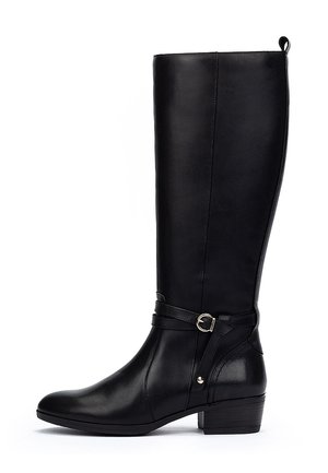 Bota negra hasta la rodilla hecha de cuero suave, con punta redondeada, un pequeño tacón cuadrado y una correa decorativa con una hebilla circular dorada.