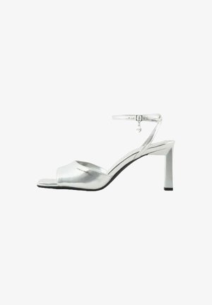 Sandali alti argentati con finitura metallica, design open toe, cinturino alla caviglia regolabile e tacco affusolato. Texture liscia su tutta la superficie.