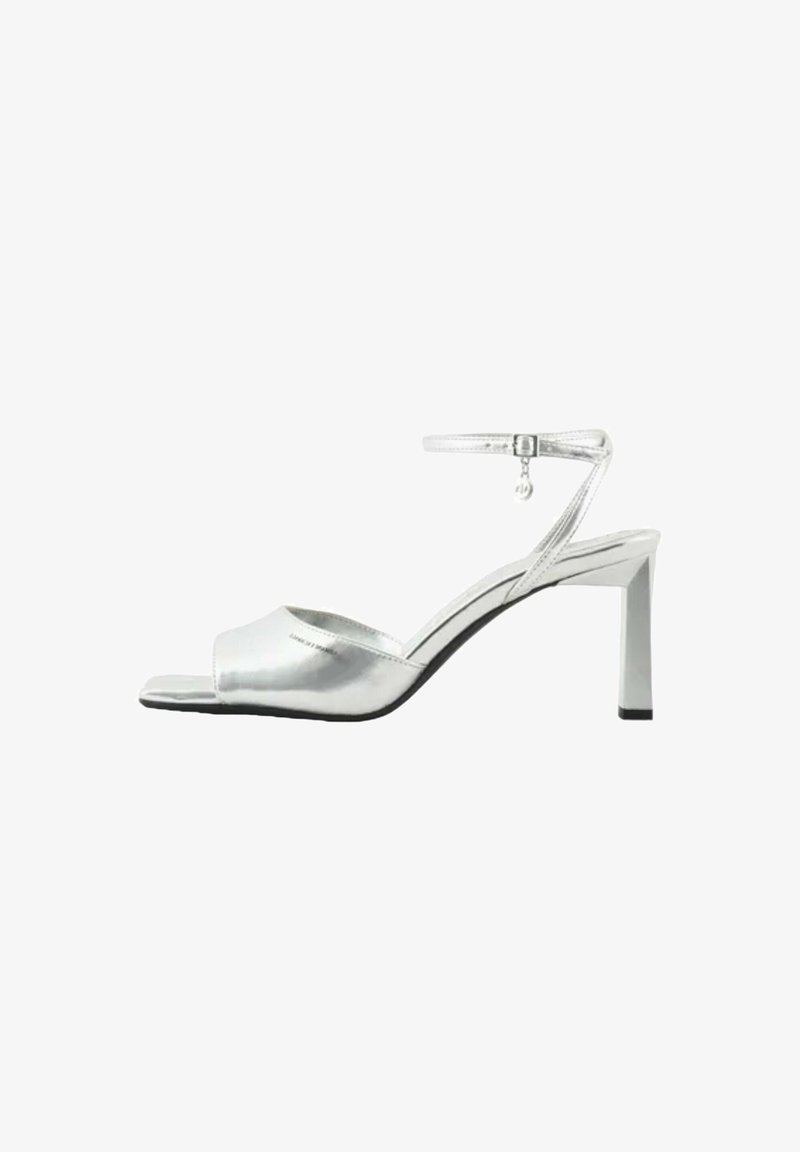 Sandali alti argentati con finitura metallica, design open toe, cinturino alla caviglia regolabile e tacco affusolato. Texture liscia su tutta la superficie.