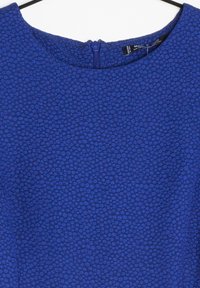 Robe bleue avec un motif texturé. Encolure ronde et courte fermeture éclair à l'arrière. Tissu lisse avec un léger éclat.
