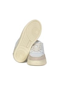 Zapatillas blancas con una suela crema, que cuentan con cuero perforado y suaves acentos de ante en la puntera, terminadas con cordones clásicos.