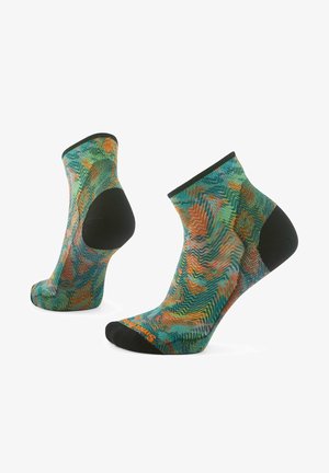 Kolorowe skarpetki na kostkę z wzorem fal w zielonym, pomarańczowym i niebieskim. Czarne akcenty na palcach i pięcie, wykonane z miękkiego, fakturowanego materiału.