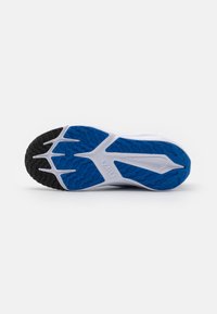 Shoe sole with a black textured rubber edge, white midsole, and blue patterned grip surface featuring ridges and grooves for traction.