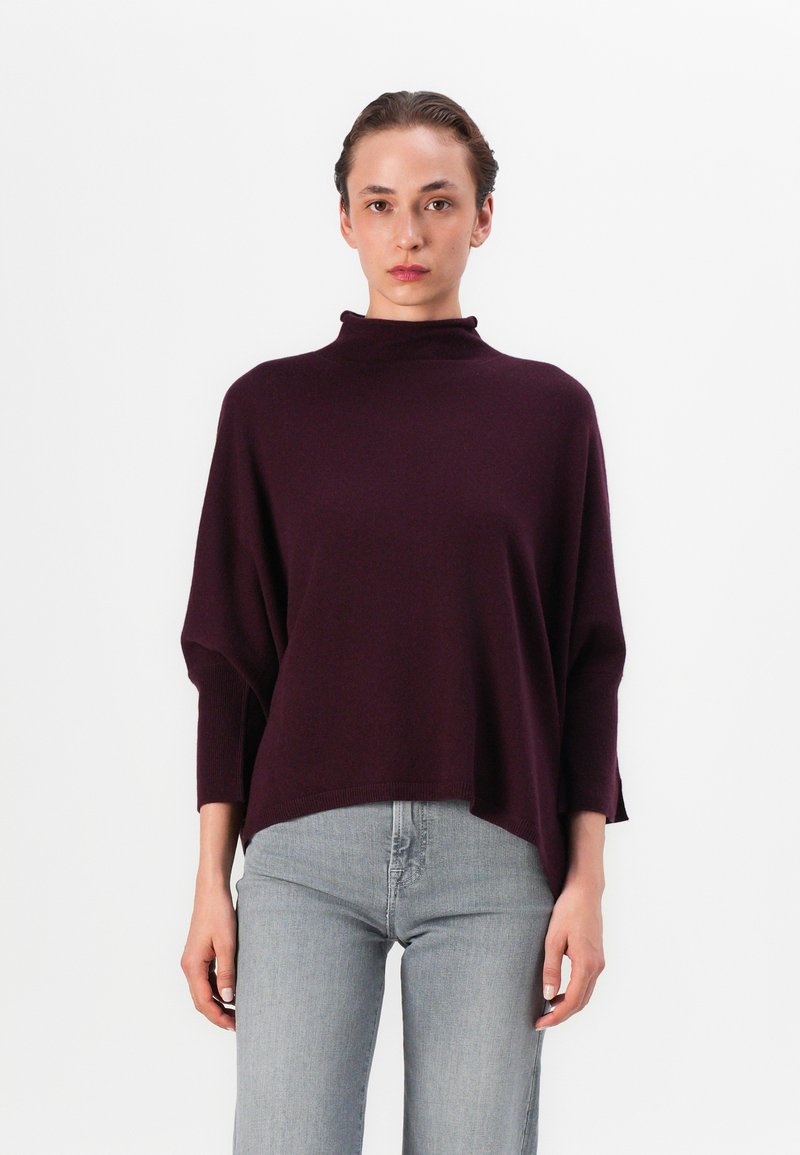 Lila Strickpullover mit hohem Ausschnitt und Dreiviertelärmel, ergänzt durch einen lässigen Schnitt und subtile gerippte Saumdetails.