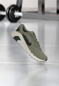 Chaussure de course en mesh vert avec un swoosh Nike noir, col rembourré et semelle intermédiaire légère, avec une tige texturée et une semelle extérieure en caoutchouc.