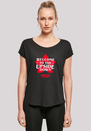 Black short-sleeve T-shirt featuring a red star graphic with the text "WELCOME TO THE UPSIDE DOWN" and "STRANGER THINGS" below.