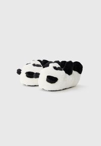 Pantufas com tema de panda em suave material felpudo branco e preto, apresentando detalhes faciais bordados e uma forma de bico arredondado.