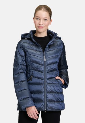 Giacca imbottita blu navy con chiusura a zip frontale, motivo trapuntato orizzontale, cappuccio e tasche laterali. La texture liscia e lucida aumenta il calore.