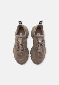 Hnědé pletené tenisky s prodyšnou texturou, šněrovacím designem, silnou gumovou podrážkou a poutkem s černo-bílým brandingem.