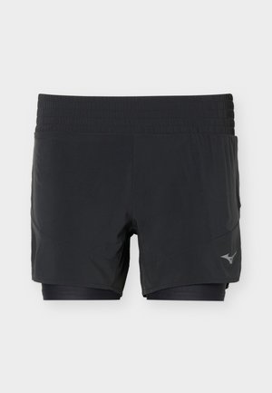 Shorts de course noirs à couches multiples avec ceinture élastique et petit logo sur la partie inférieure de la jambe droite, présentés sur fond blanc uni.
