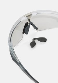 Graue transparente Schutzbrille mit verstellbarem Nasenpolster. Mit glatten Bügeln und klaren Gläsern, entwickelt für Schutz und Komfort.