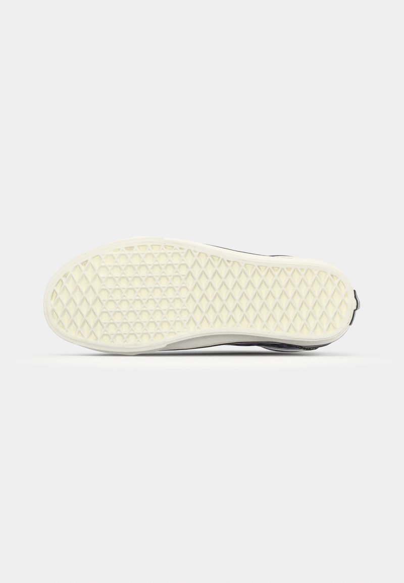 Semelle de chaussure en caoutchouc blanc avec un motif hexagonal, présentant un bord supérieur noir. Texture lisse avec une légère finition brillante.