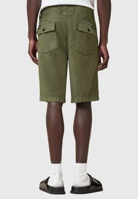 Pantaloni cargo verde oliva con due tasche posteriori, passanti per la cintura anteriori e orlo risvoltato. Il tessuto appare leggero e textured.