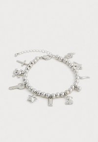 Ασημένια βραχιόλι με χάντρες, διακοσμημένο με charms σε σχήμα κλειδιού, αστεριού, σταυρού, κρανίου, αρκούδου, κραγιόν, φίδι, δαχτυλίδι και φύλλο σε λευκό φόντο.