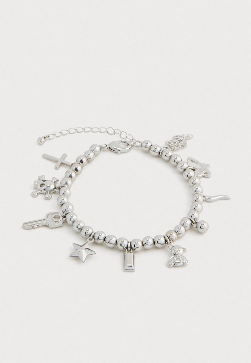 Ασημένια βραχιόλι με χάντρες, διακοσμημένο με charms σε σχήμα κλειδιού, αστεριού, σταυρού, κρανίου, αρκούδου, κραγιόν, φίδι, δαχτυλίδι και φύλλο σε λευκό φόντο.