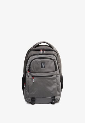 Pilkas kuprinė, pagaminta iš patvarios medžiagos; turi kelis užtrauktukus užsegamus skyrius, paminkštintus diržus ir logotipo pleistrą priekyje.