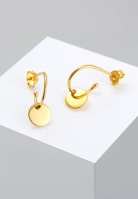 Cercei din aur cu pandantive circulare. Textură netedă, finisaj strălucitor, atașate cu un accent din piatră prețioasă la spate. Design minimalist.