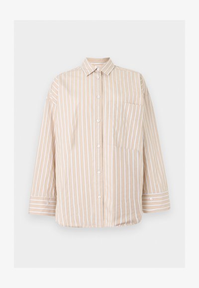 Chemise beige à boutons avec des rayures blanches verticales, une poche avant avec des rayures diagonales, et des manches longues avec poignets boutonnés.