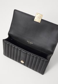 Black leather wallet with a textured quilted design, gold hardware clasp, and internal branding. Opened to show compartments and lining.
