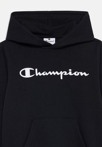 Felpa nera con cappuccio realizzata in tessuto morbido, caratterizzata da un logo bianco "Champion" sulla parte anteriore. Presenta una comoda tasca frontale e un cappuccio regolabile con coulisse.