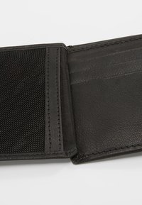 Portefeuille en cuir noir avec une finition texturée, comportant une poche en maille et plusieurs emplacements pour cartes. L'intérieur présente des coutures lisses.