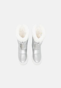 Silver waterproof boots with plush white faux fur lining, padded design, and white rubber soles; logo displayed on the side.